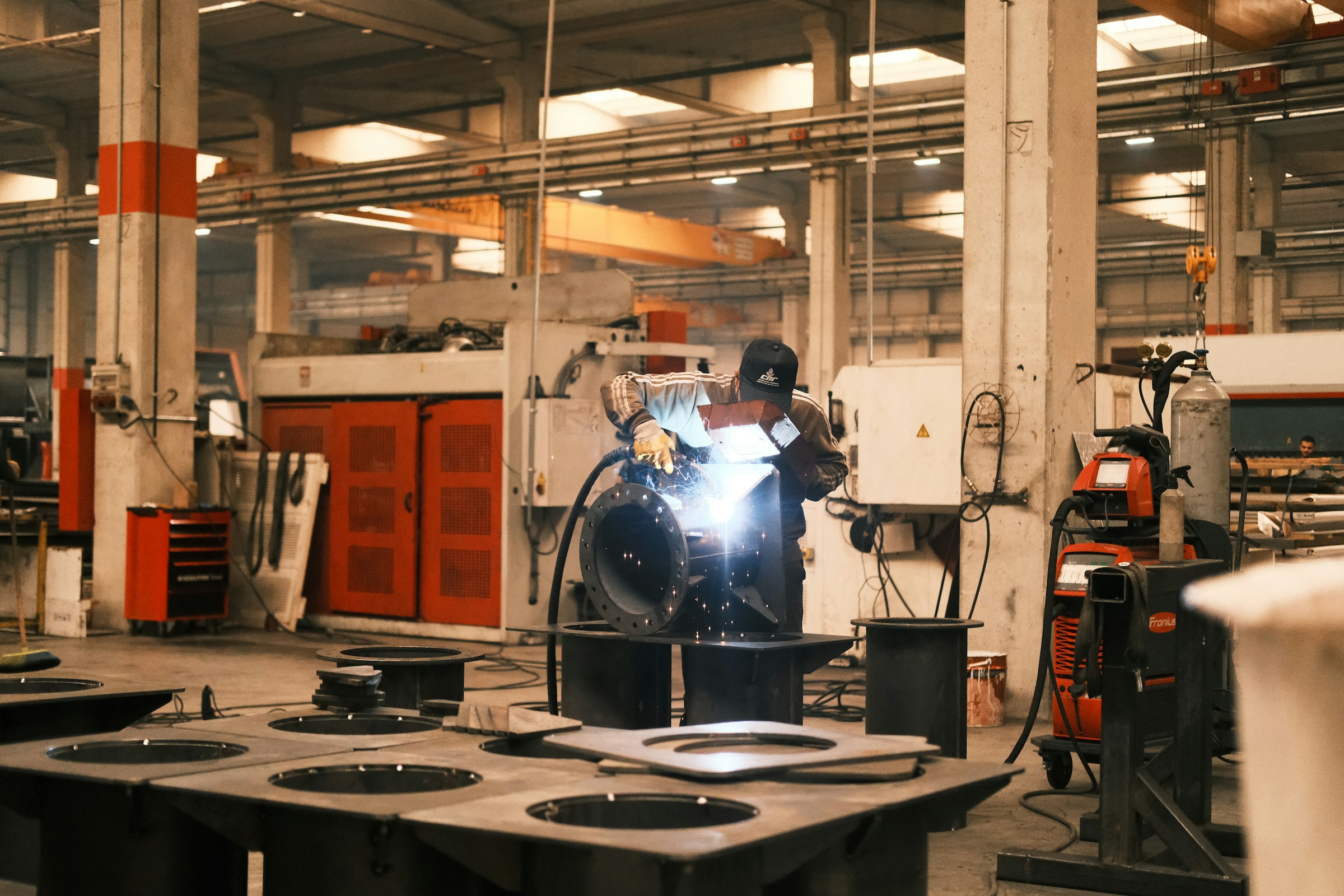 Welder working on metal in a factory